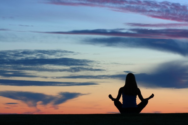 female practicing yoga at sunset