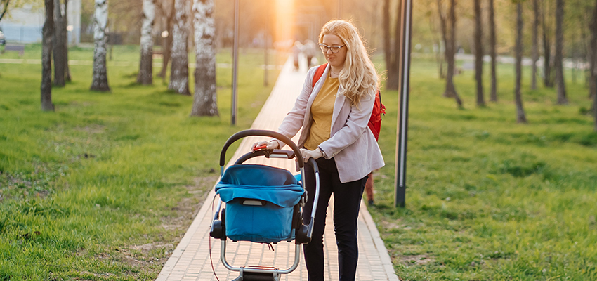 mom walks with a stroller in the park